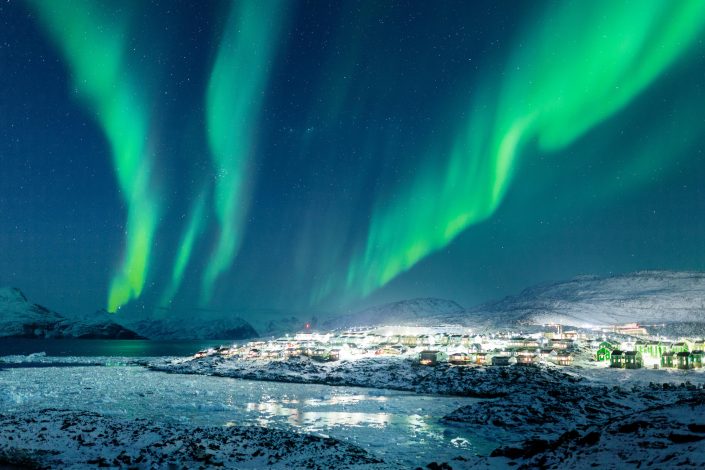 northern-lights-over-the-city-lights-of-nussuaq-nuuk-in-greenland-705x470